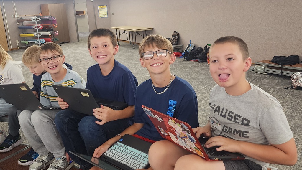 students posing while working on chromebooks