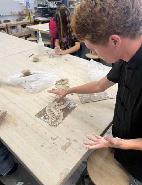 Student sculpts clay