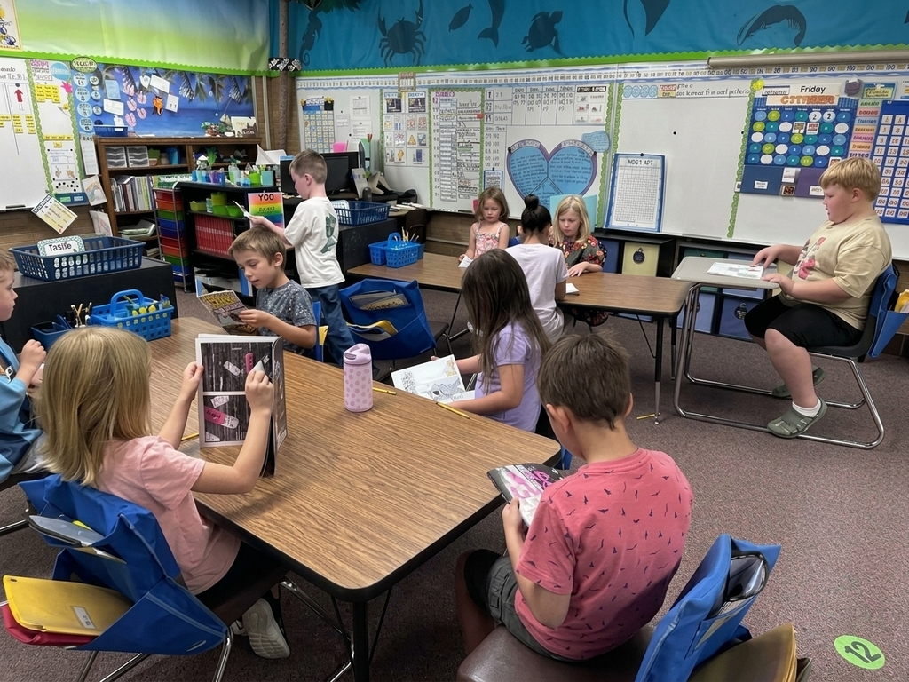 Students sitting around classroom tables quietly reading books during the statewide read-a-thon.