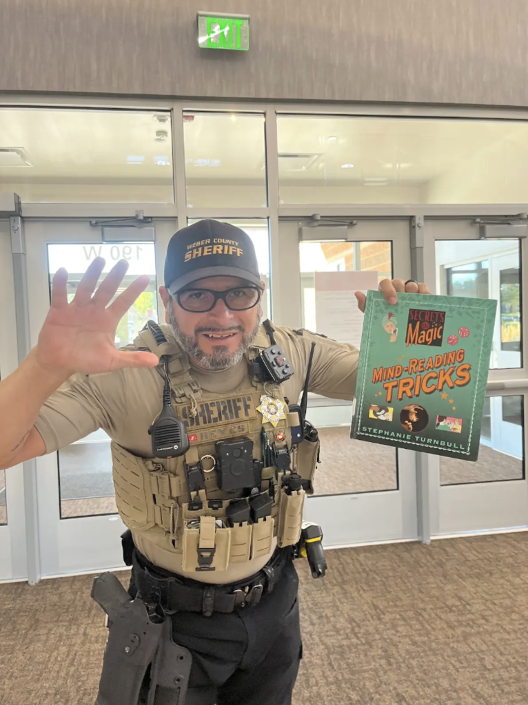 school resource officer holding a book