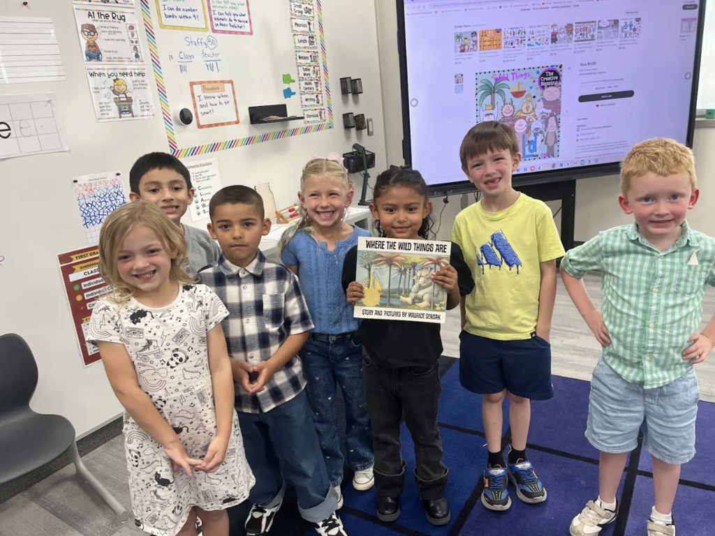 a group of students holding a book that they read as a class
