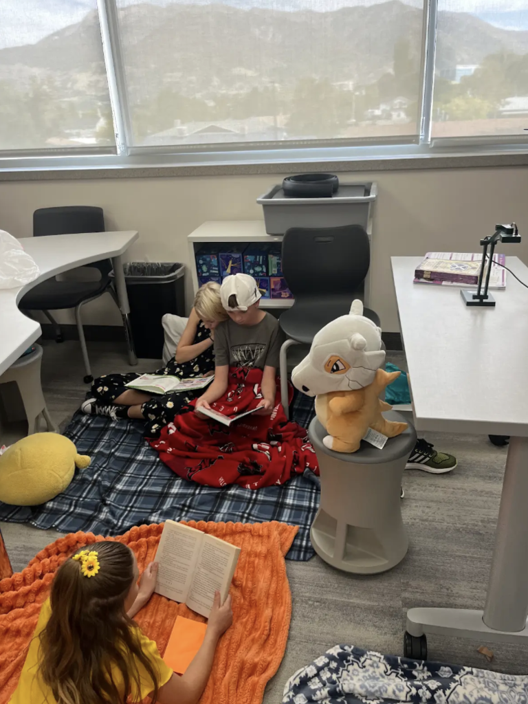 students reading on a blanket in a classroom