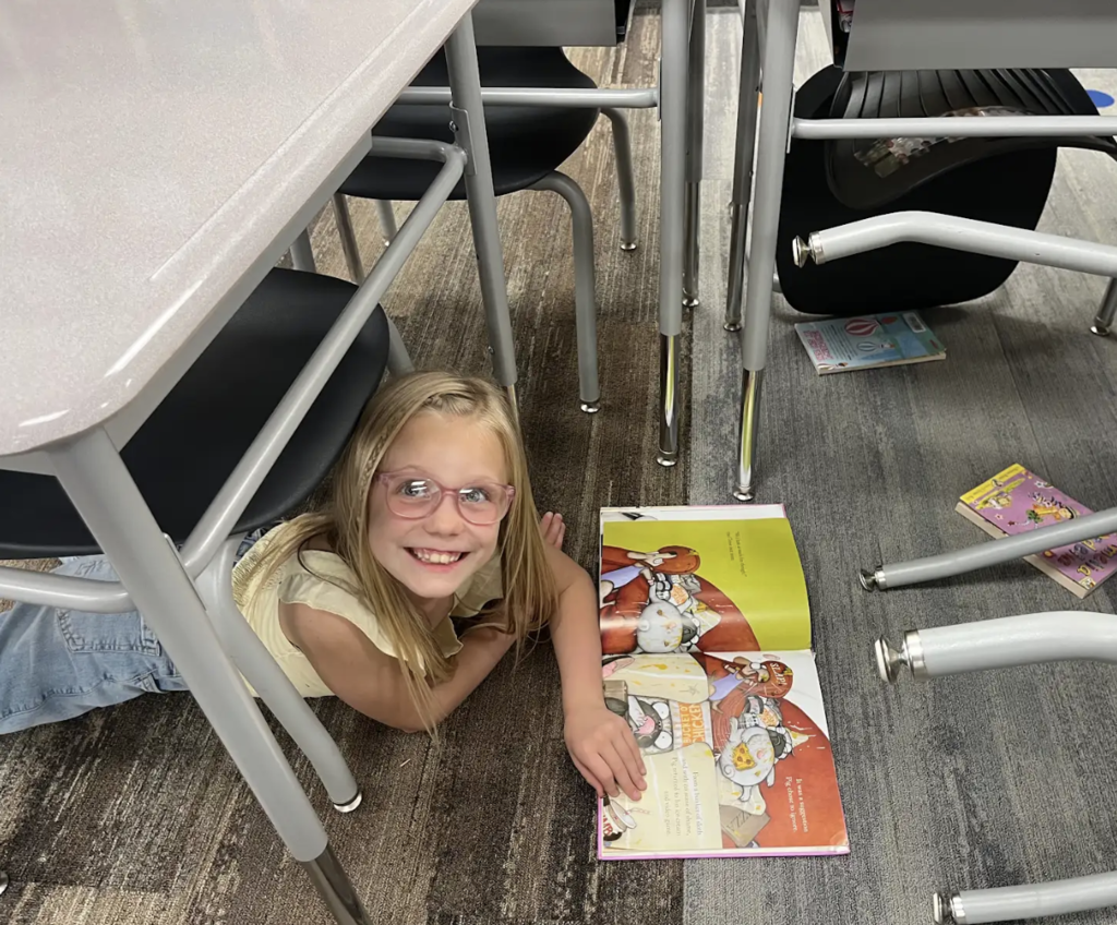 student reading under a desk