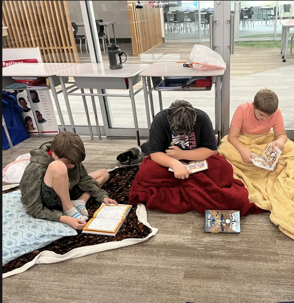 3 boys sitting on the floor with blankets reading