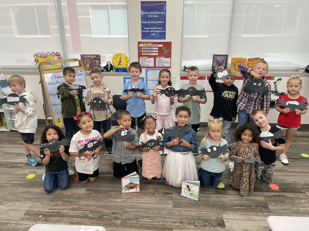 students holding spiders that they created after their read about spider books