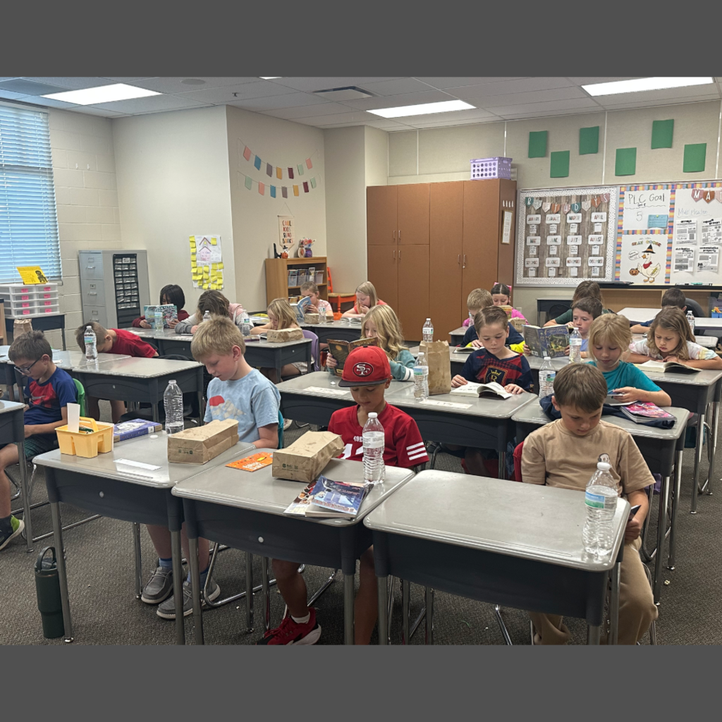 Students reading at their desk in their classroom.