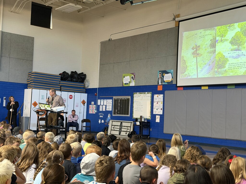 Students listening to Superintendency reading a book.