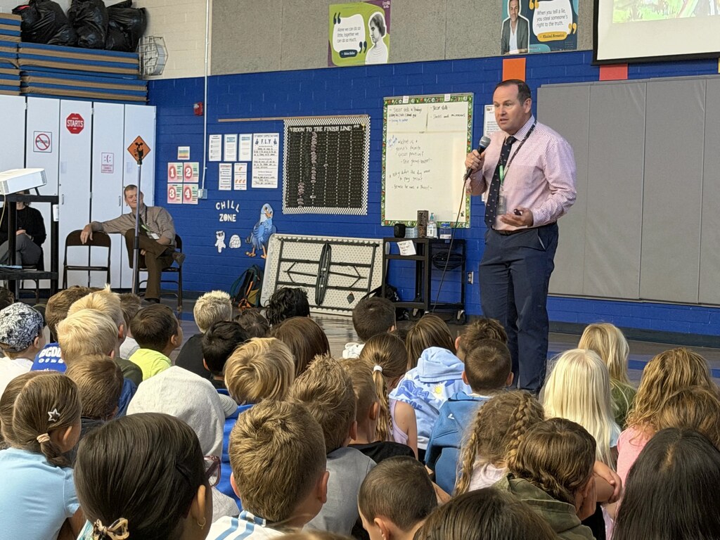 Students listening to Superintendency reading a book.