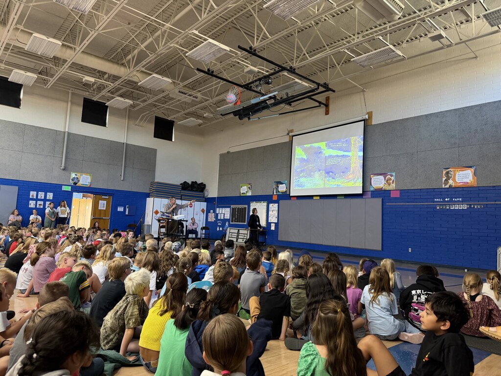 Students listening to Superintendency reading a book.