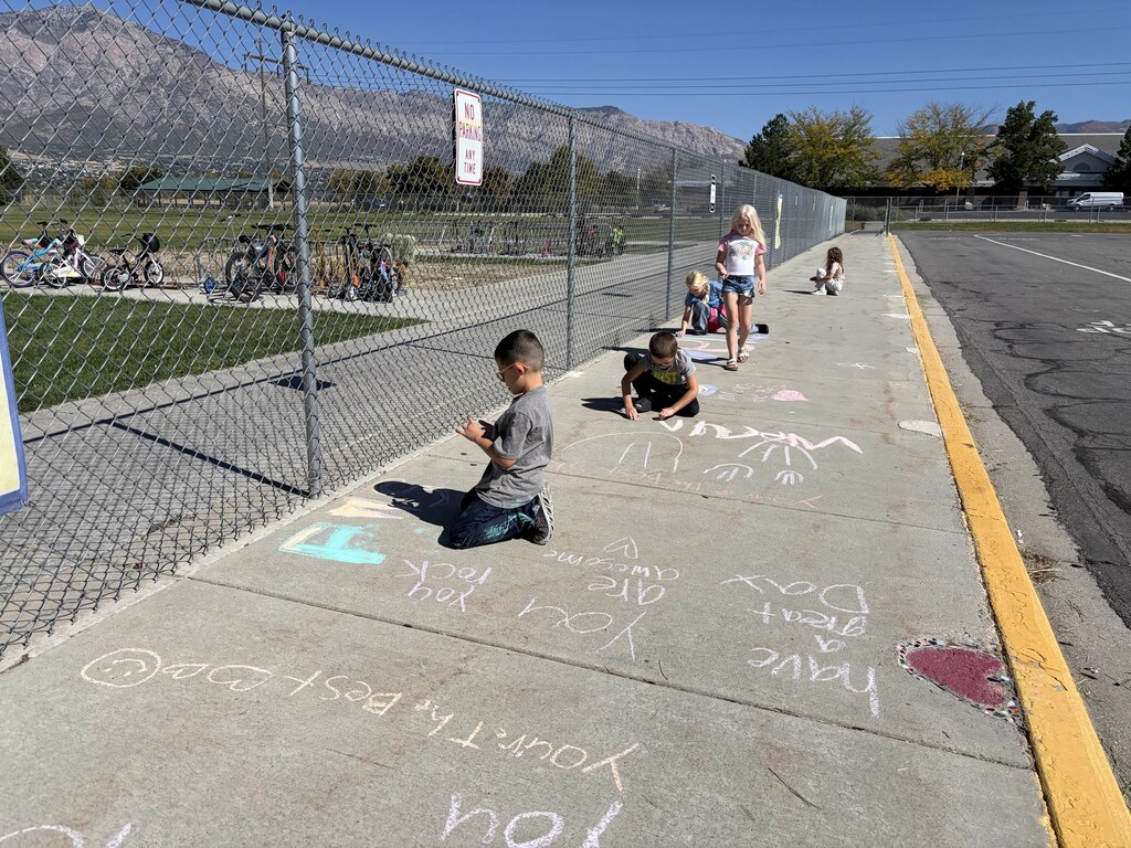 2nd graders chalking kind messages