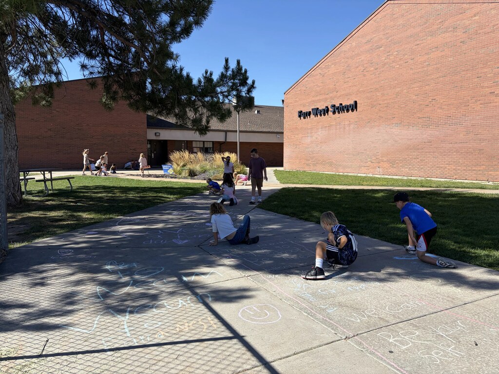 2nd graders chalking kind messages