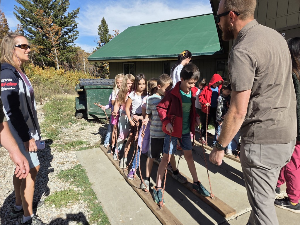 students standing on two boards holding strings