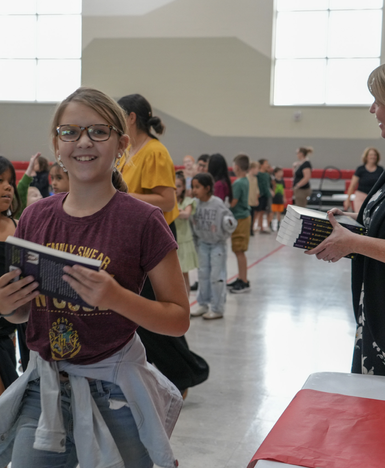 student holding her new book