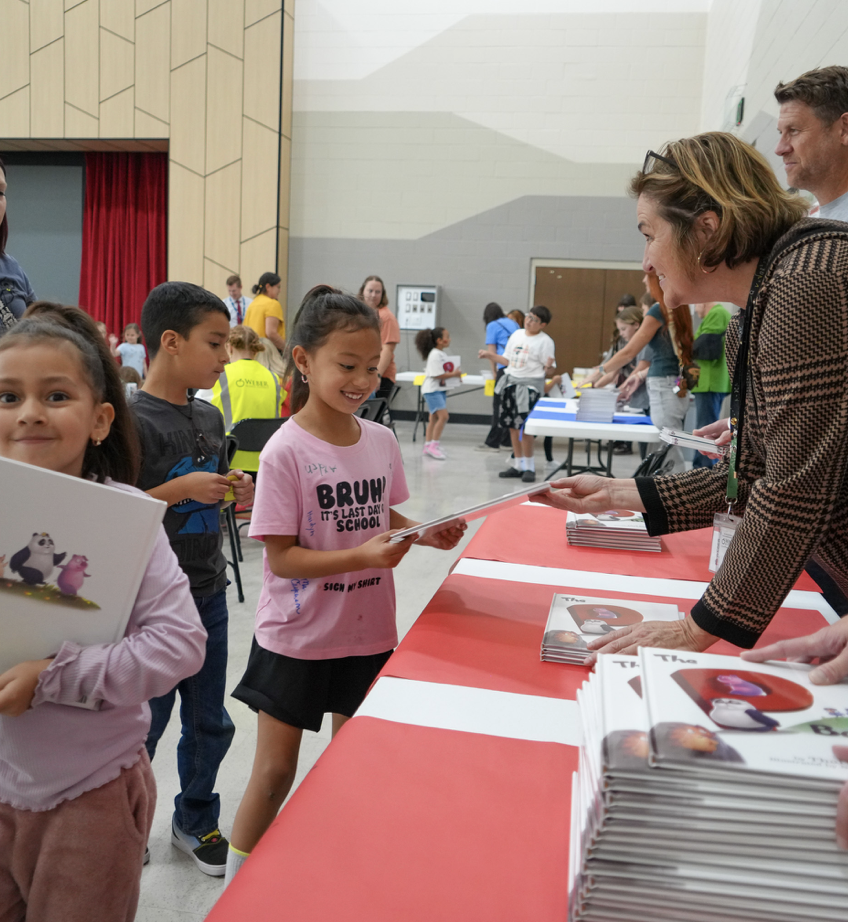 students holding their new books