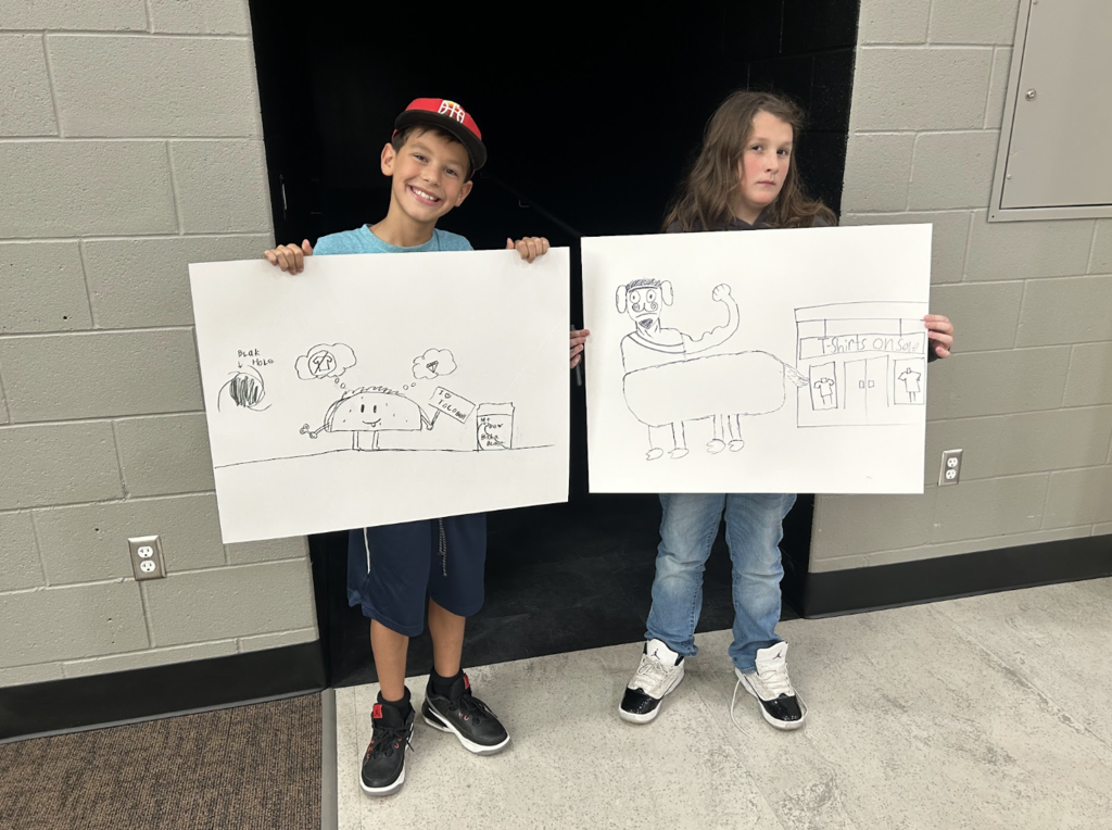 two students holding up their illustrations