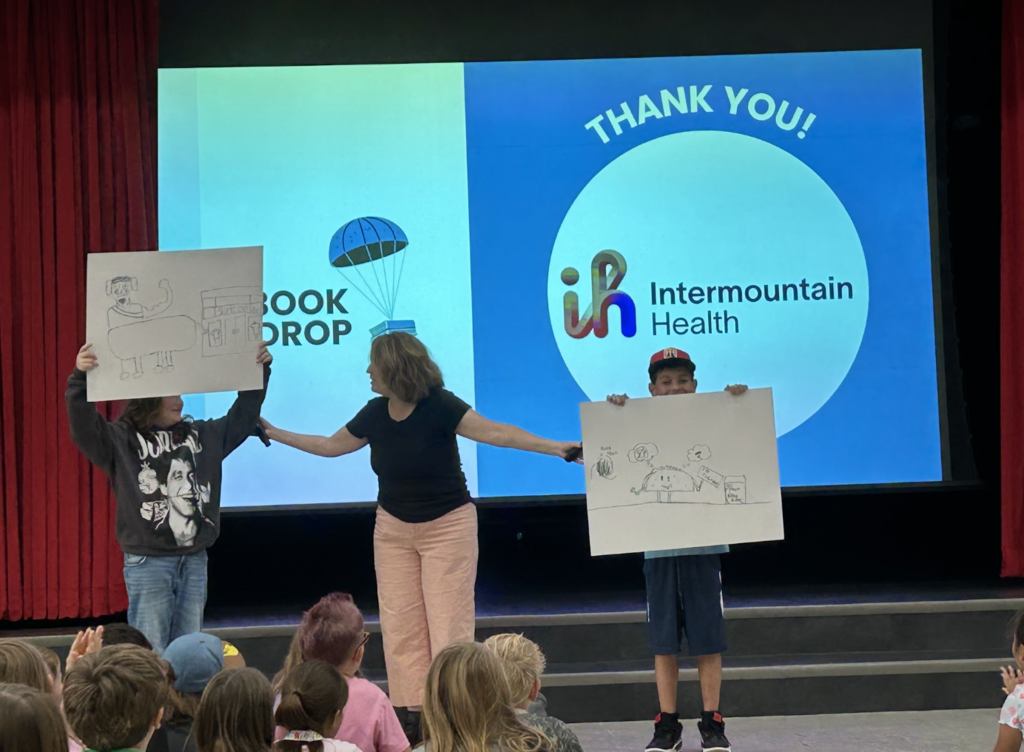 Jennifer A. Nielsen standing with two students as they hold up their illustrations