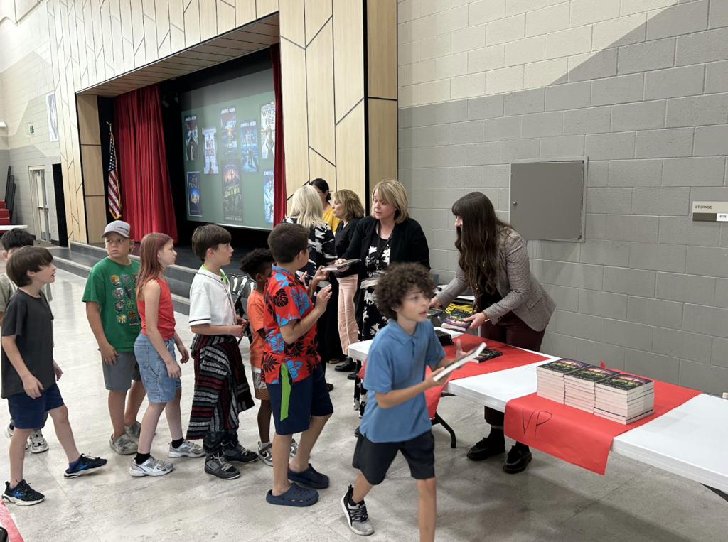 students walking in a line to receive their books