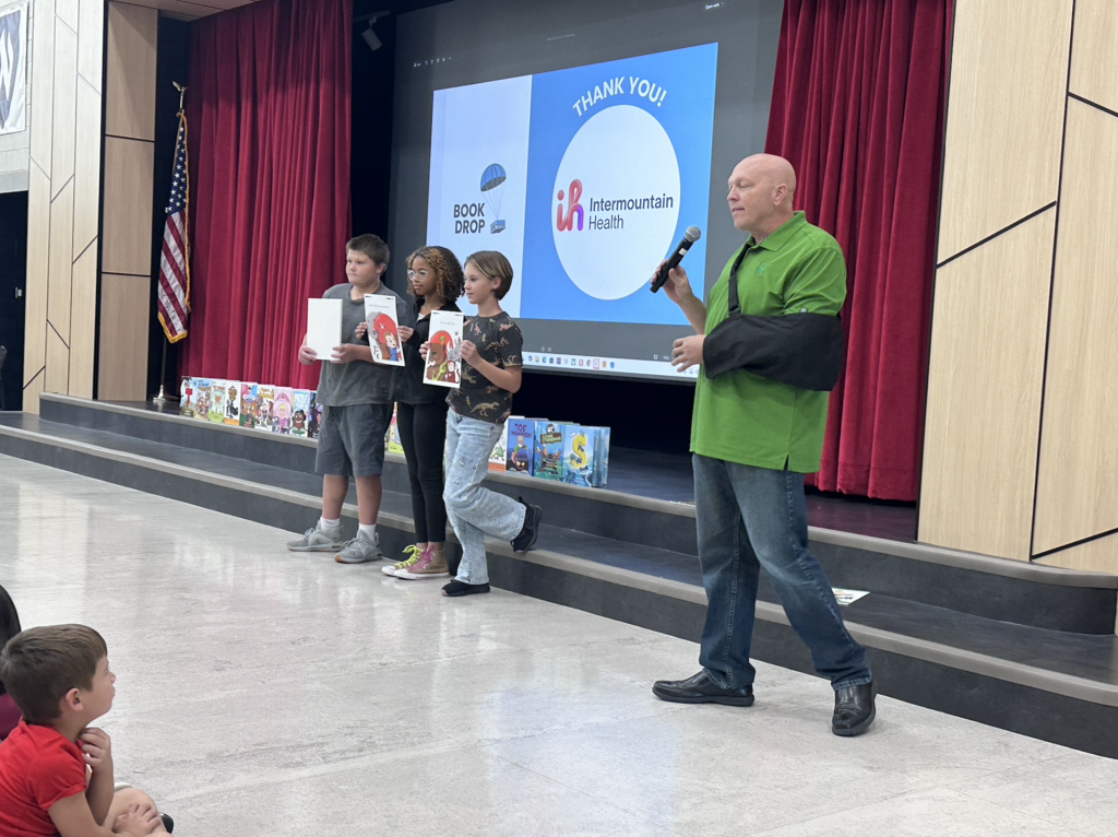 thal dixion presenting in an assembly as 3 student hold pictures