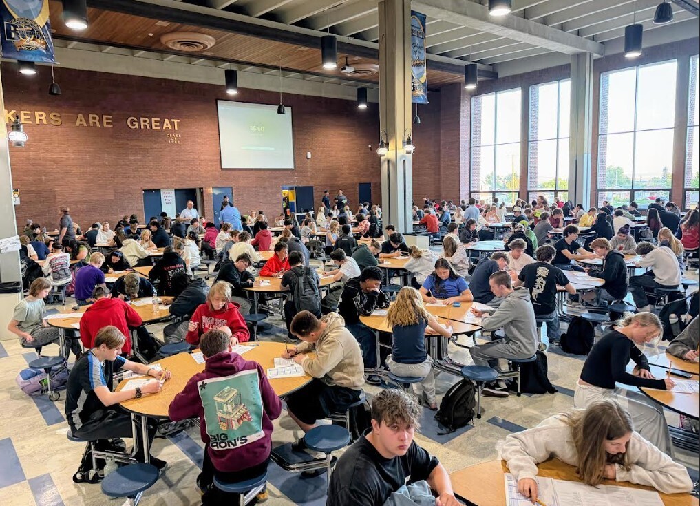 Students sitting in the cafeteria working on the practice ACT