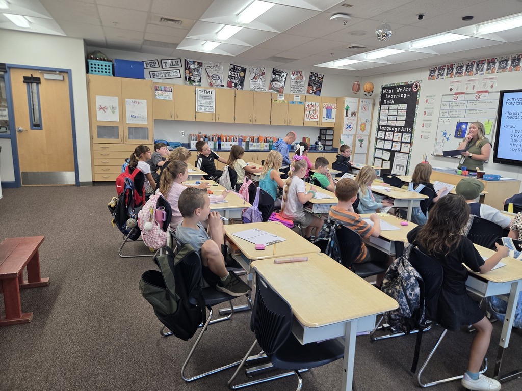 students sitting in desks listening to mrs. moyes teach