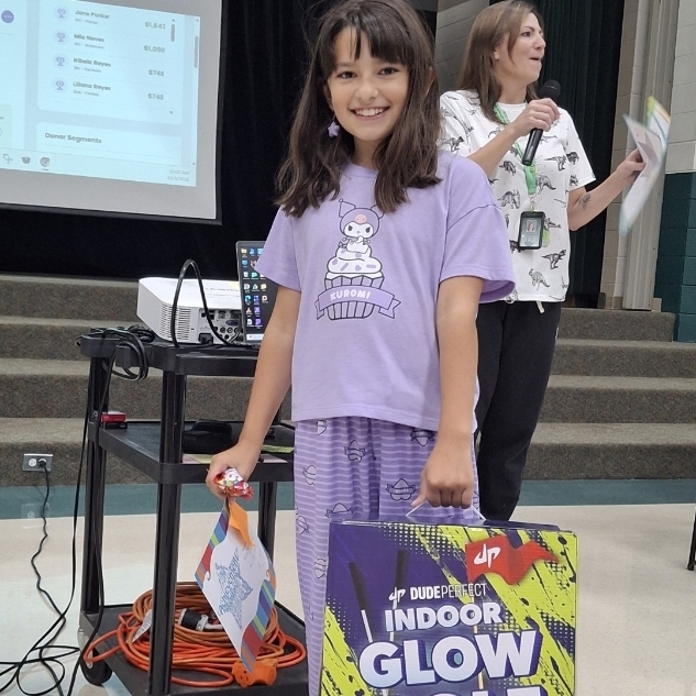 girl holding a Glow Golf fundraiser prize