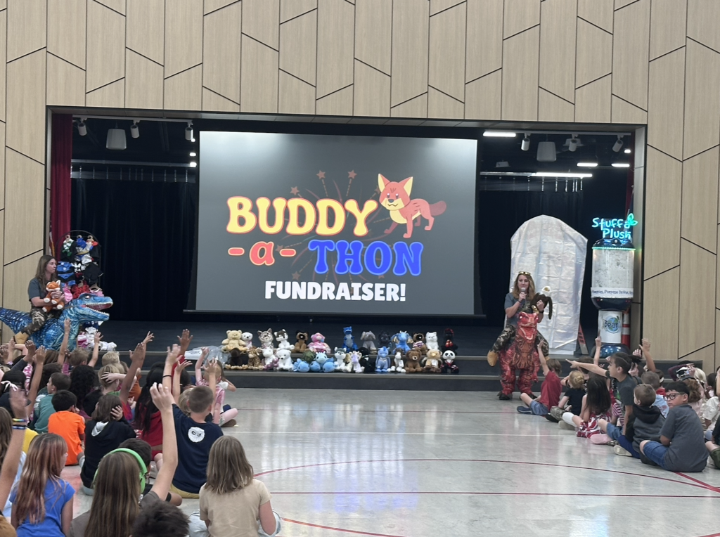 Buddy-a-thon fundraiser on screen with stuffed animal buddies sitting on the stage