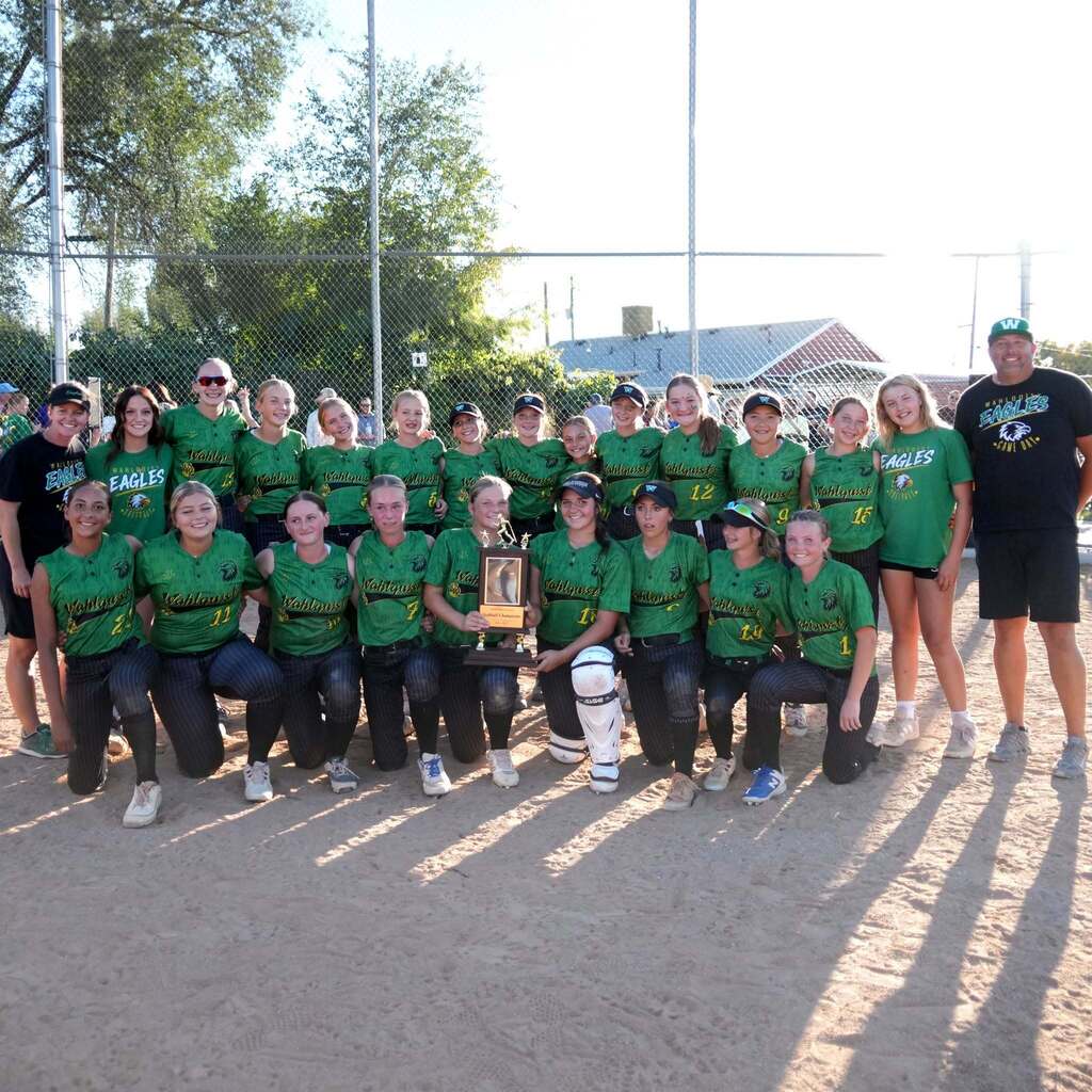 Image 10: The Wahlquist Eagles junior high softball team and coaches gathered together on the field proudly holding up their championship trophy.