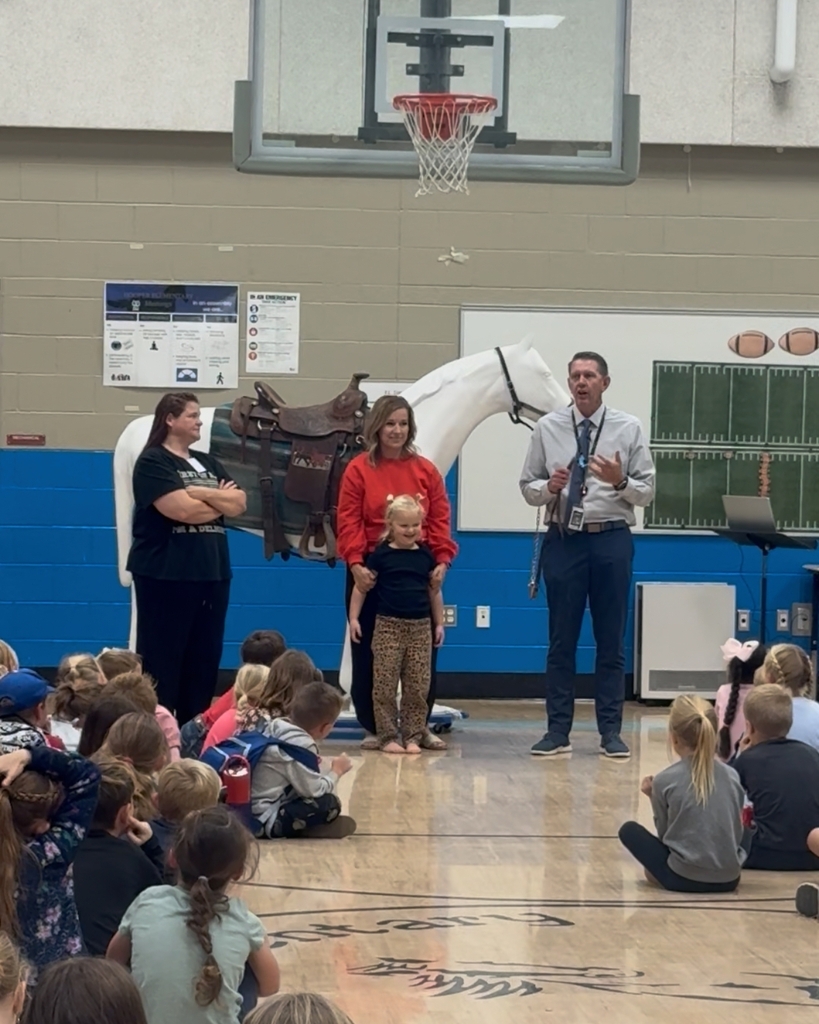Photos from a school assembly at Hooper Elementary where students learned what it means to be a Mustang by showing grit, growth, and kindness. Additional photos feature a large Mustang mascot display that will be showcased at the front of the school.