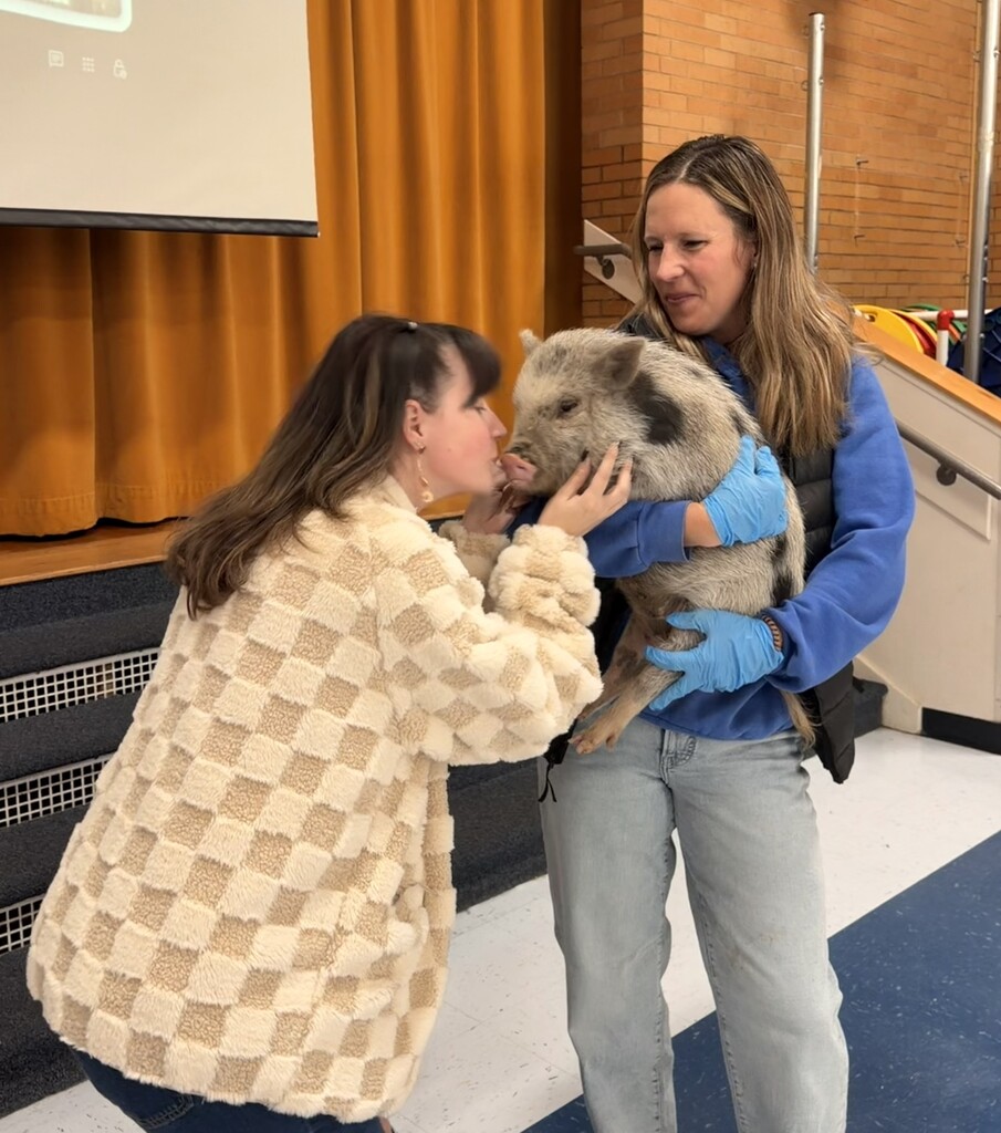Faculty staff kissing a pig