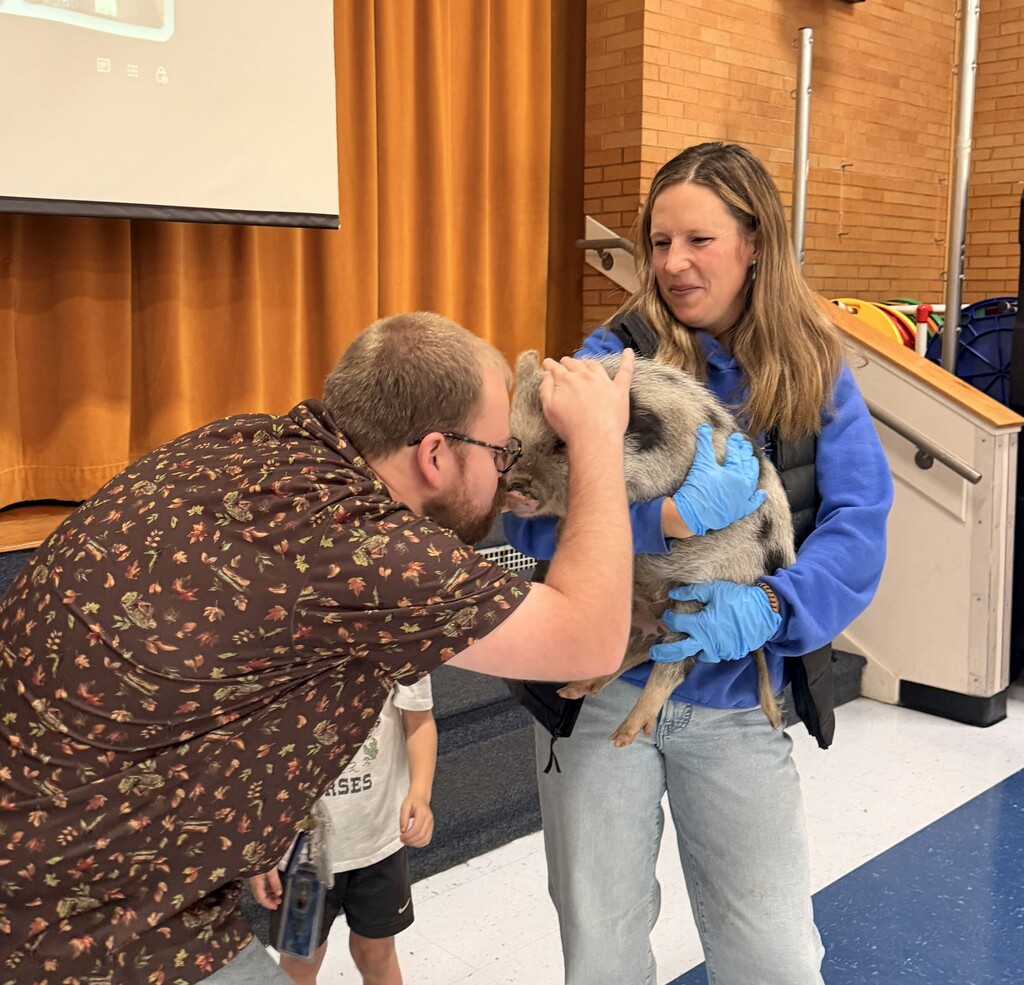 Faculty staff kissing a pig