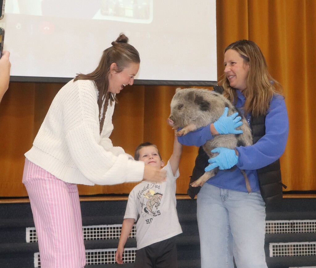 Faculty staff kissing a pig