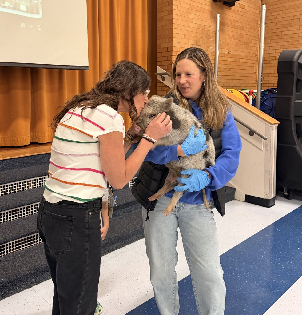 Faculty staff kissing a pig