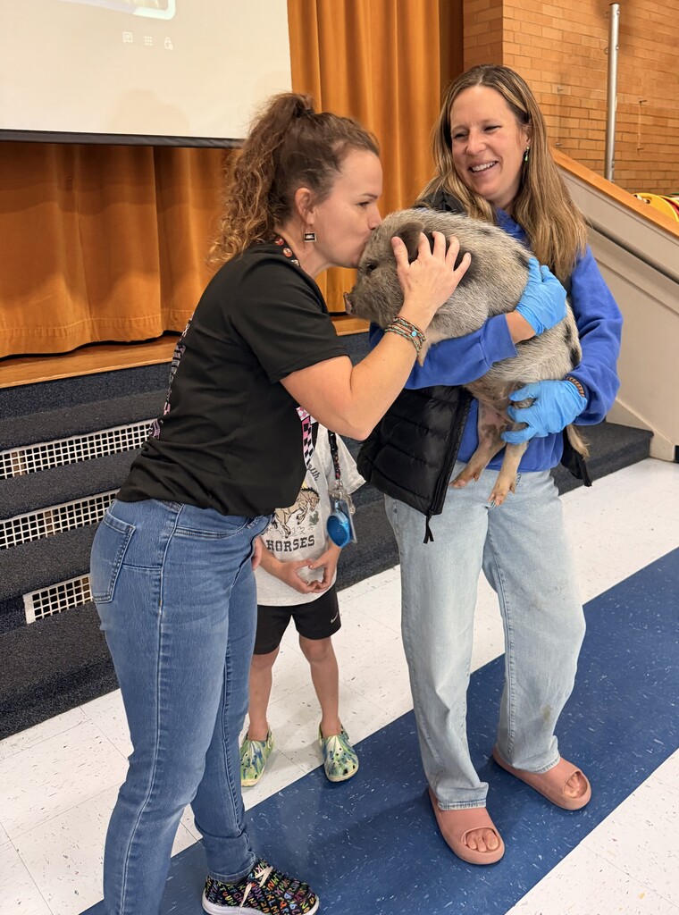 Faculty staff kissing a pig