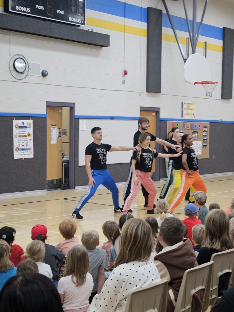 Close-up shot of dancers in matching "Dance is for Everybody" shirts performing dynamic choreography.