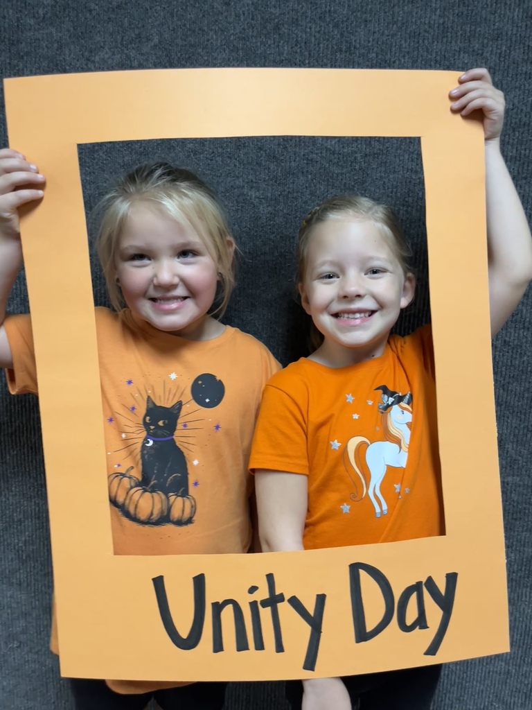 Great shot of smiling students posing behind the "Unity Day" frame.
