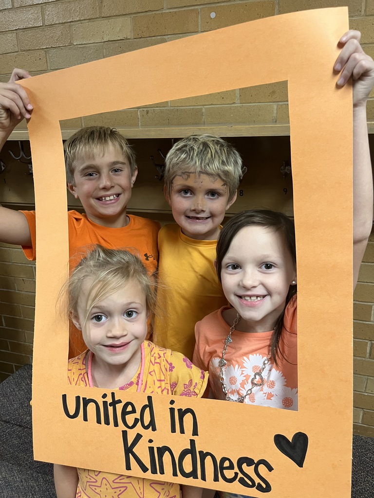 Great shot of smiling students posing behind the "Unity Day" frame.