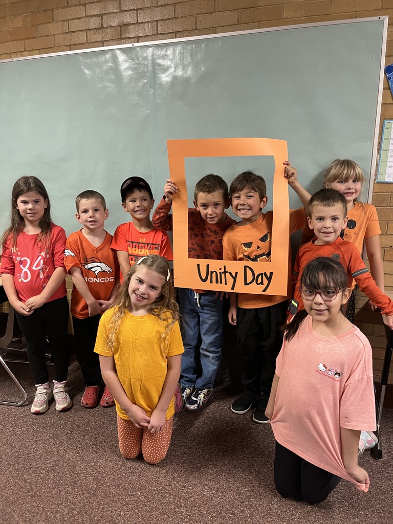 Great shot of smiling students posing behind the "Unity Day" frame.