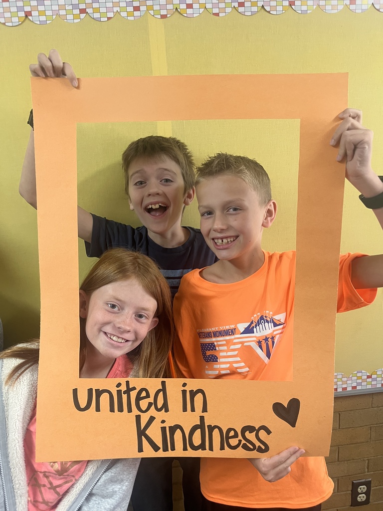 Great shot of smiling students posing behind the "Unity Day" frame.