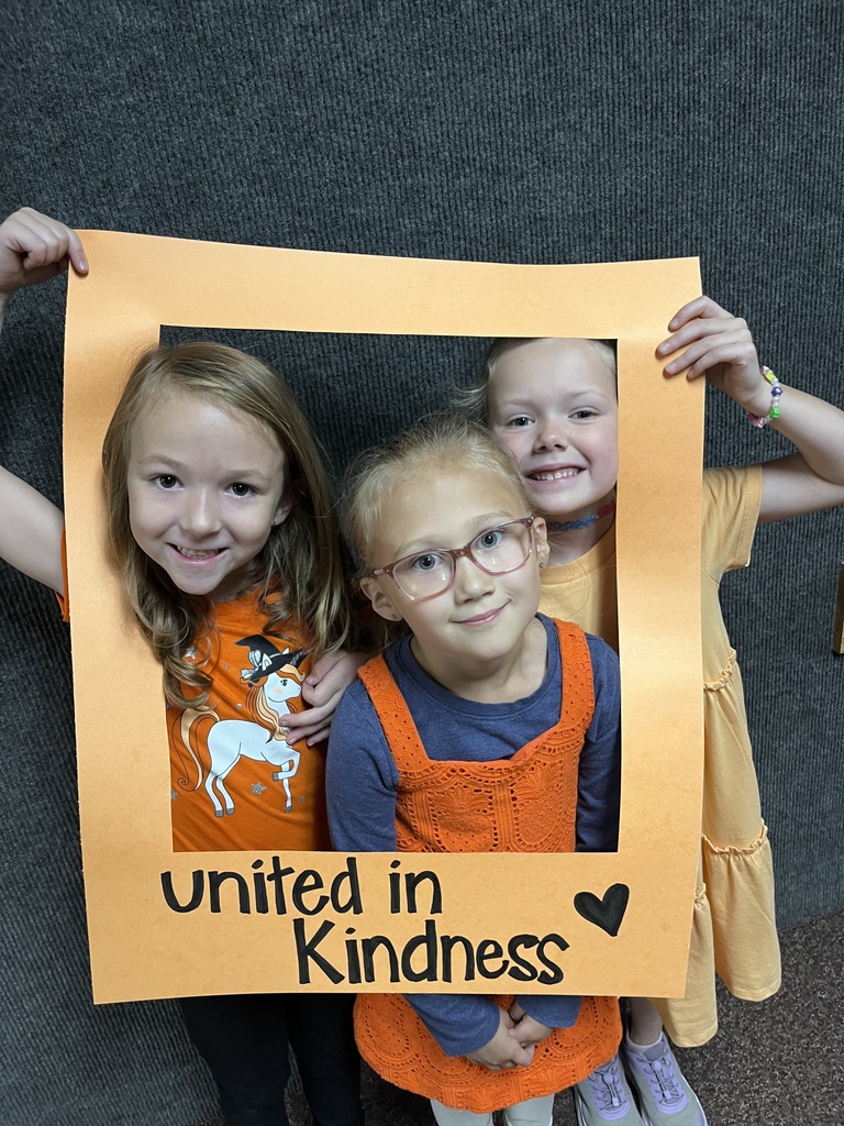 Great shot of smiling students posing behind the "Unity Day" frame.