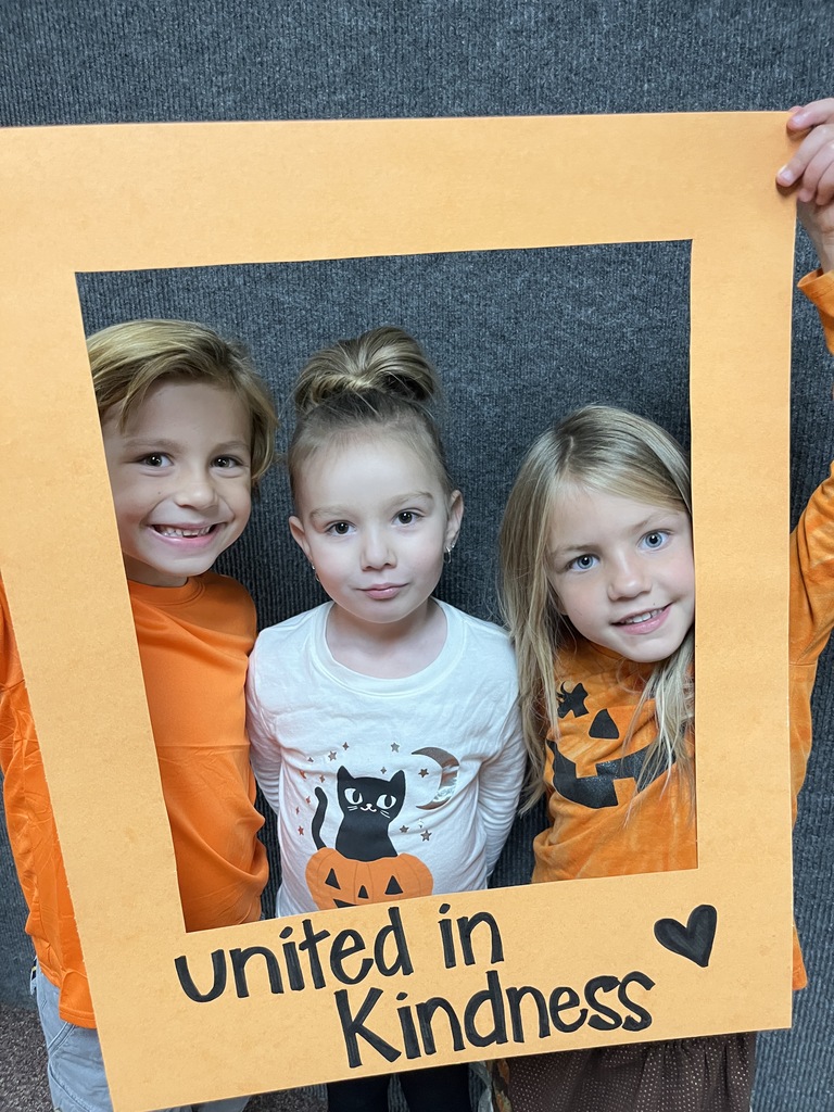 Great shot of smiling students posing behind the "Unity Day" frame.