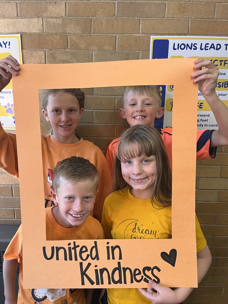 Great shot of smiling students posing behind the "Unity Day" frame.