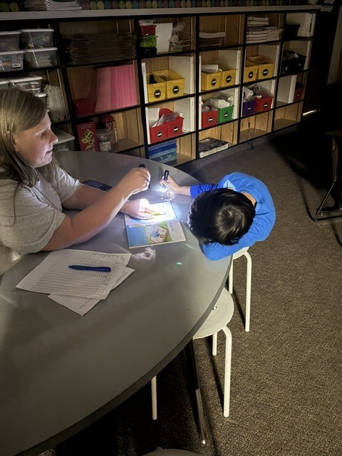 Mrs. Melo reading with a student