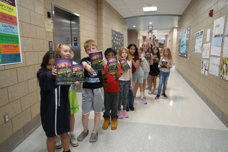 Students enjoying the Book drop assembly with Thal Dixon and Jennifer A. Nielsen.