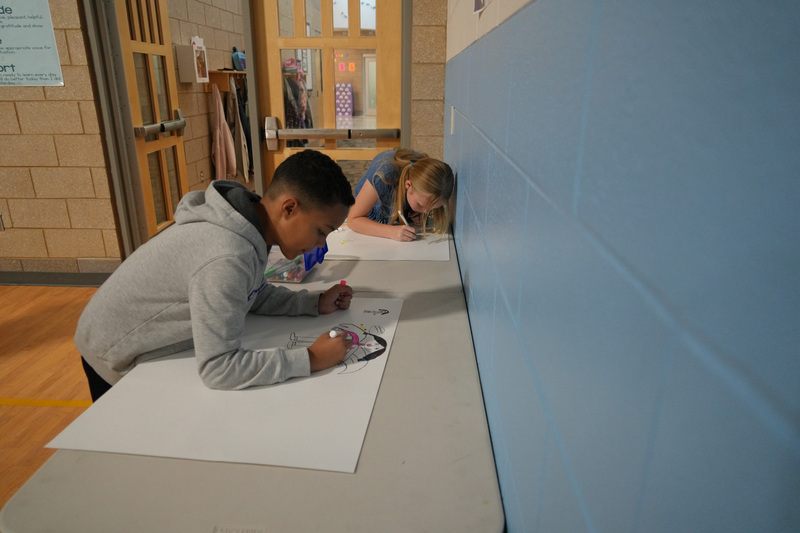 Students enjoying the Book drop assembly with Thal Dixon and Jennifer A. Nielsen.