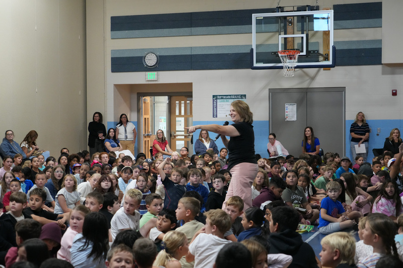 Students enjoying the Book drop assembly with Thal Dixon and Jennifer A. Nielsen.