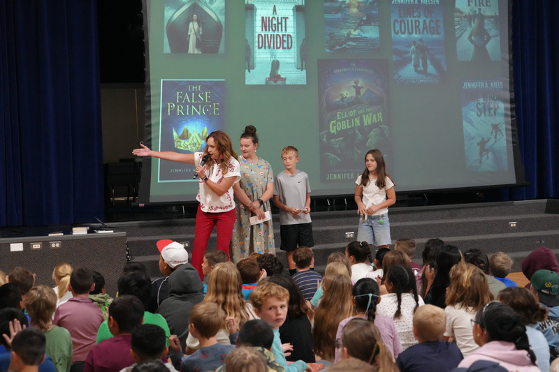 Students enjoying the Book drop assembly with Thal Dixon and Jennifer A. Nielsen.