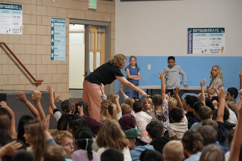 Students enjoying the Book drop assembly with Thal Dixon and Jennifer A. Nielsen.