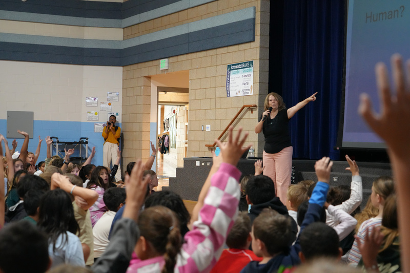 Students enjoying the Book drop assembly with Thal Dixon and Jennifer A. Nielsen.