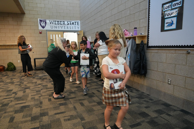 Students enjoying the Book drop assembly with Thal Dixon and Jennifer A. Nielsen.