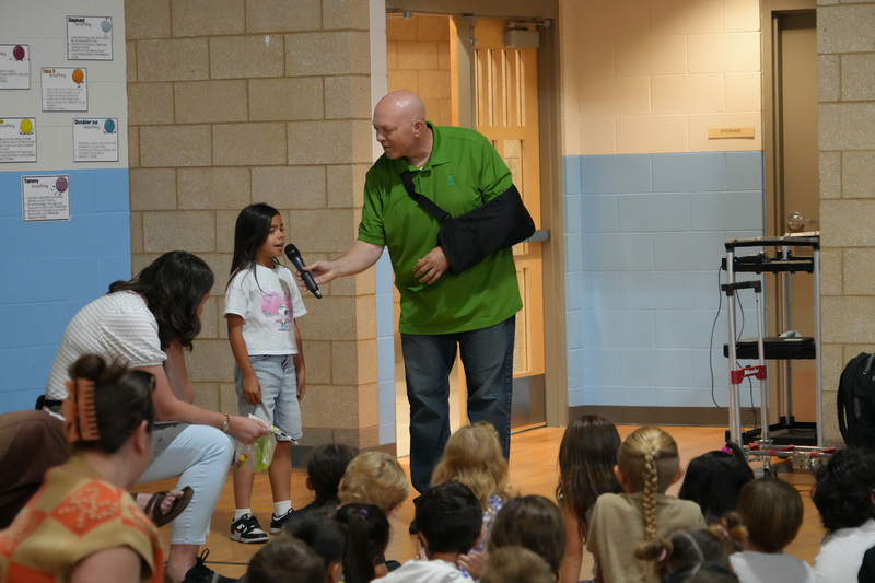 Students enjoying the Book drop assembly with Thal Dixon and Jennifer A. Nielsen.